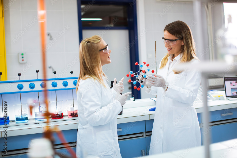 Female chemists hold molecular model in the lab
