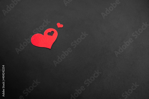 Big and small hearts on dark background. Valentines Day postcard. Copy space.