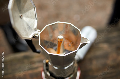 Process of making camping coffee outdoor with metal geyser coffee maker on a gas burner, step by step