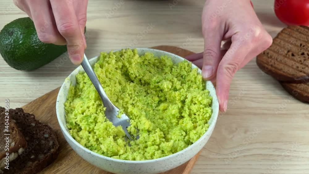 Woman hand preparing avocado salad Woman hand preparing avocado salad