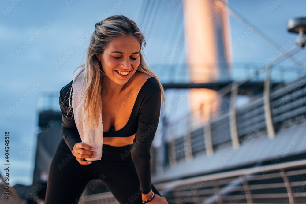 young woman smiling after finishing her outdoor workout