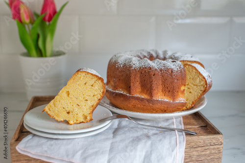 Fresh vanilla bundt cake on a wooden cutting board