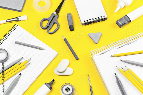 Assorted gray office and school stationery office supplies on yellow desk. Selective focus banner. education craft art or back to school. notebook. Illuminating and bright copy space grey monochrome