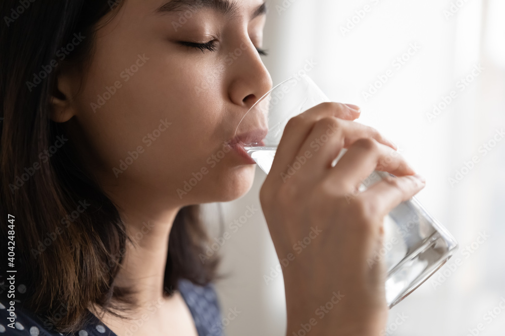Closeup millennial asian korean mixed race woman drinking crystal clear water, feeling thirsty in morning, peaceful multiracial lady enjoying daily healthcare lifestyle habit, preventing dehydration. Closeup millennial asian korean mixed race woman drinking crystal clear water, feeling thirsty in morning, peaceful multiracial lady enjoying daily healthcare lifestyle habit, preventing dehydration.