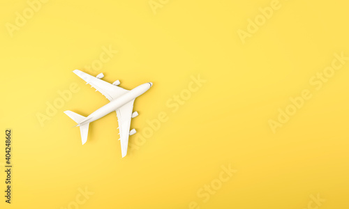 White plane on yellow background. Flat lay of travel concept.