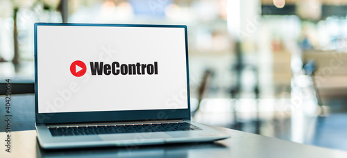 Laptop computer displaying 'we control' sign