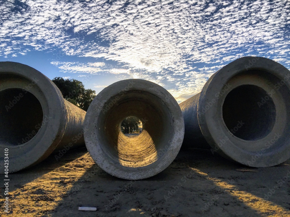 Large water main pipes on the ground with light shinning through Large water main pipes on the ground with light shinning through