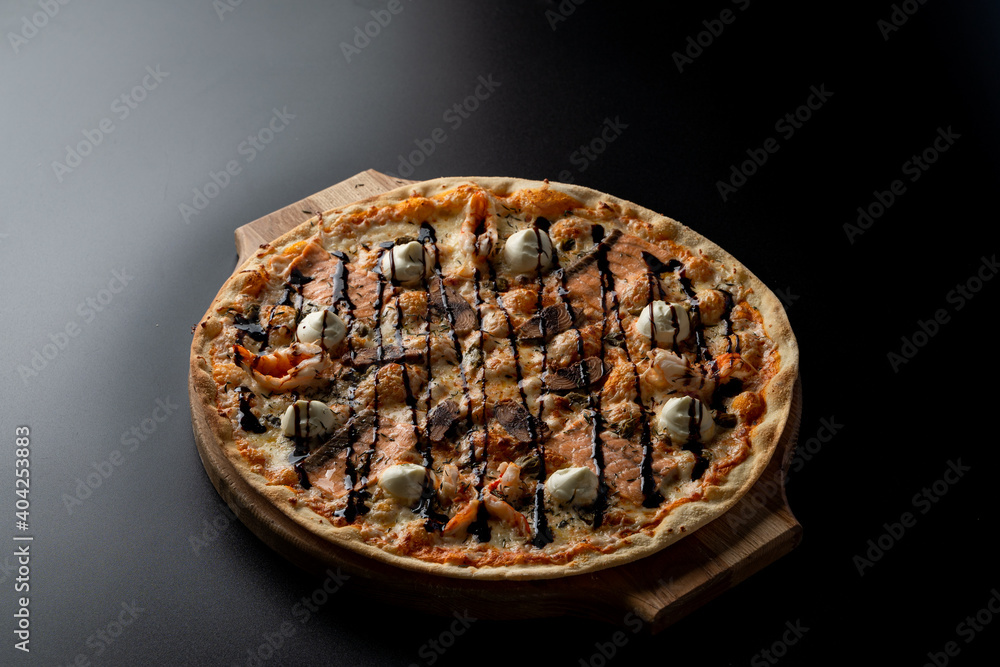 Smoked salmon pizza with small mozzarella balls on thin crispy dough,?black smooth background Smoked salmon pizza with small mozzarella balls on thin crispy dough,?black smooth background