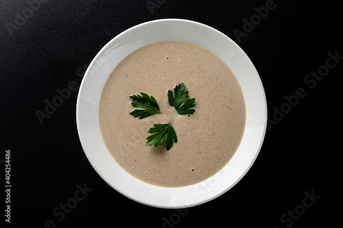 Minimalist and stylish photo for a restaurant menu: creamy mushroom soup with herbs