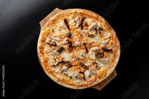 Top view of chicken and mushroom pizza with melted bright yellow cheddar cheese