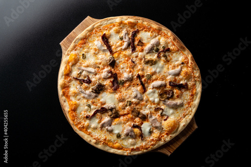 Top view of chicken and mushroom pizza with melted bright yellow cheddar cheese