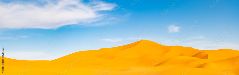 (Selective focus) Stunning view of some sand dunes illuminated during a sunny day in Merzouga, Morocco. Natural background with copy space.