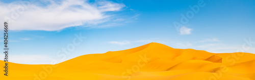 (Selective focus) Stunning view of some sand dunes illuminated during a sunny day in Merzouga, Morocco. Natural background with copy space.