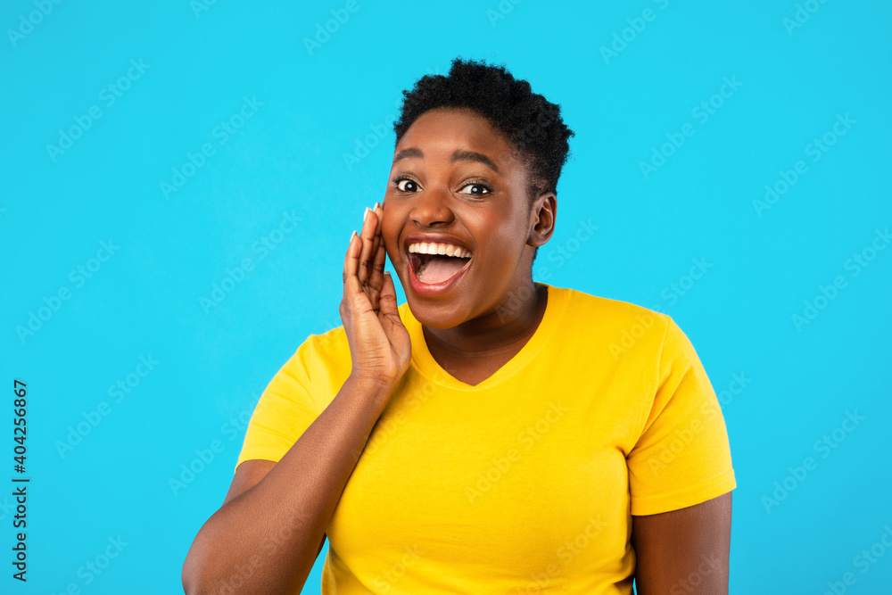 Black Plus-Size Woman Shouting Holding Hand Near Mouth, Blue Background Black Plus-Size Woman Shouting Holding Hand Near Mouth, Blue Background