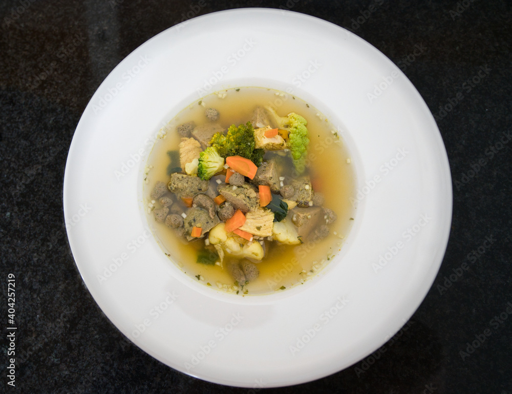 Ein weißer Teller Gemüsesuppe, Hühnersuppe mit Karotten, Leberknödel und Bio Gemüse, Produktbild Ein weißer Teller Gemüsesuppe, Hühnersuppe mit Karotten, Leberknödel und Bio Gemüse, Produktbild