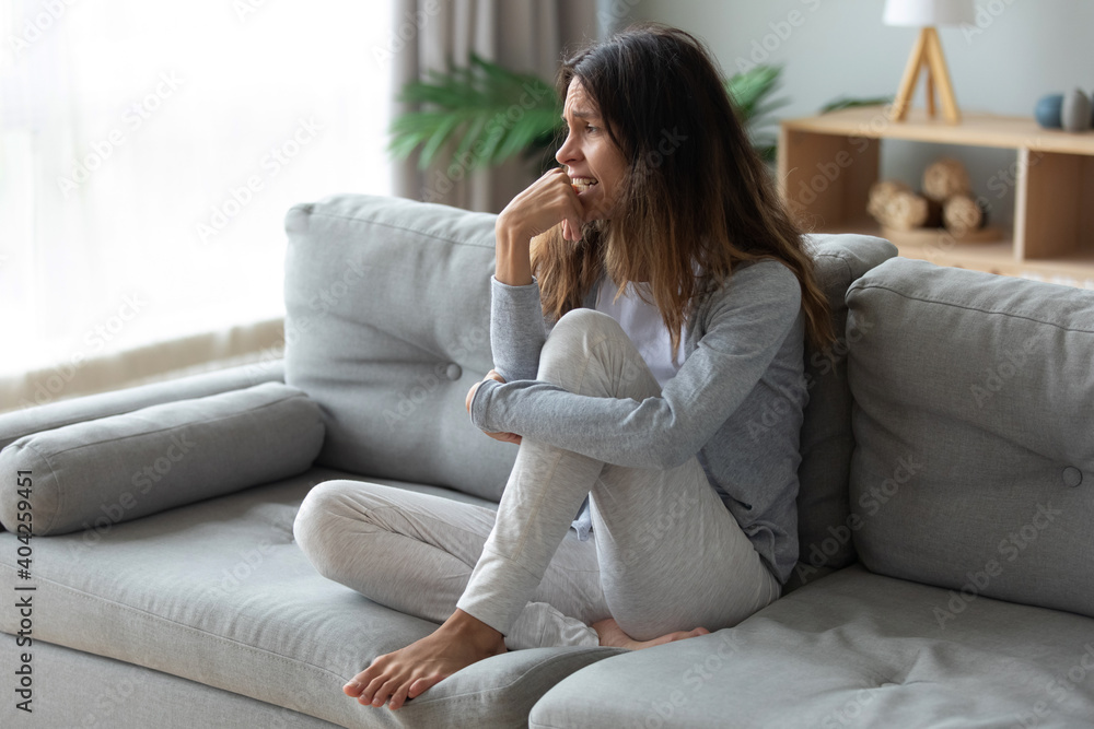 Frustrated unhappy woman crying, sitting on couch at home alone, thinking about personal problem, break up with boyfriend or divorce, need psychological help, feeling lonely and depressed - obrazy, fototapety, plakaty 