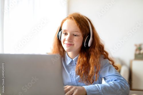 Girl wearing headphones using laptop for online education