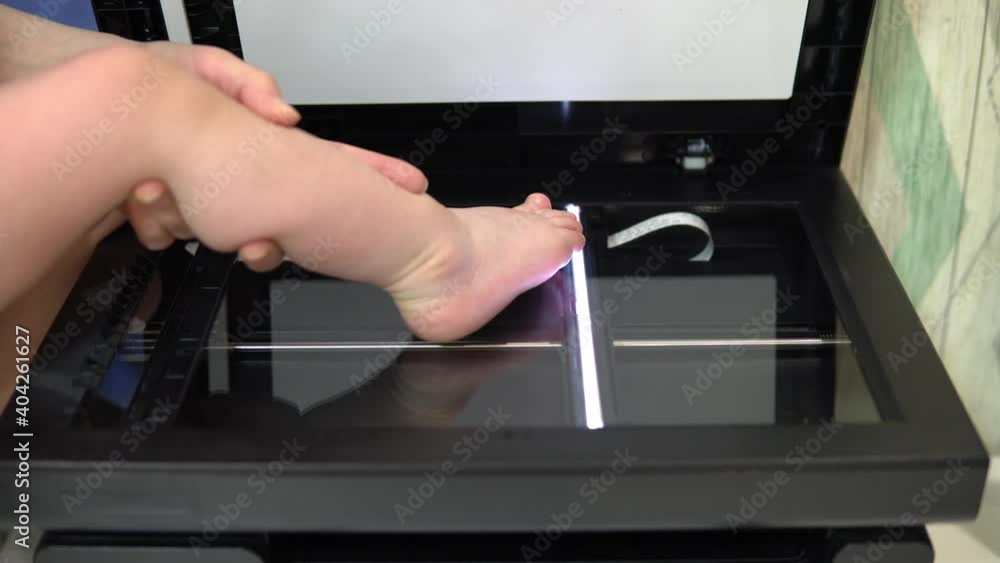 Leg scan process. The scanner in operation scans a child's foot with ...