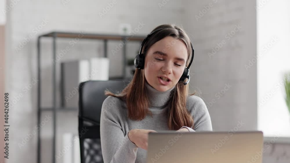 Smiling woman using laptop and wireless headset for online meeting, video call, video conference. Communication online with colleagues, relatives, friends. Online education, remote working Smiling woman using laptop and wireless headset for online meeting, video call, video conference. Communication online with colleagues, relatives, friends. Online education, remote working