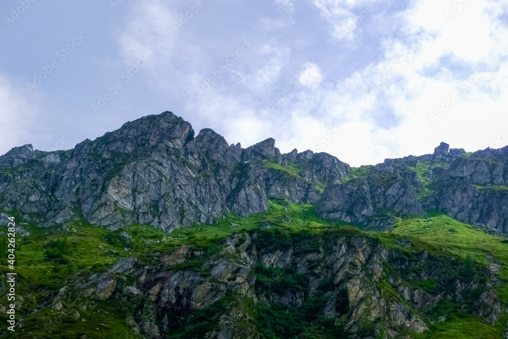 high pointed rocky mountains with green plants