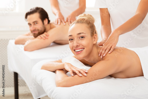 Cheerful Spouses Receiving Relaxing Back Massage Lying Indoor