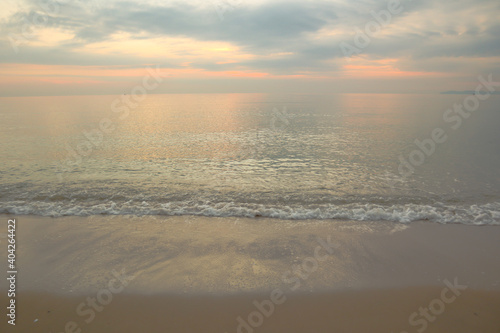 Beautiful sand beach background with soft wave on twilight sky.