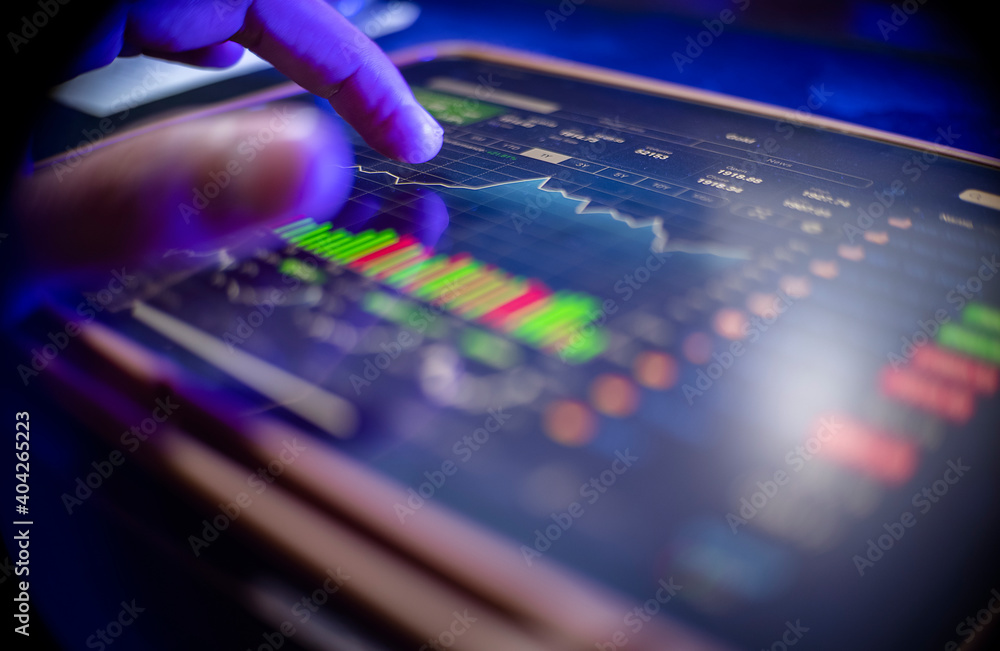 Man use finger analysis forex concurrency stock graph market for trading forex to profit by order sell or buy in night at home closeup Man use finger analysis forex concurrency stock graph market for trading forex to profit by order sell or buy in night at home closeup