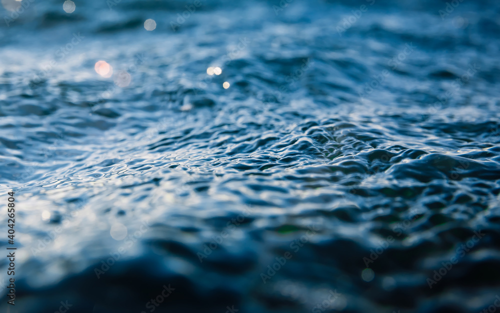 Waves at surface of ocean. Water texture with bokeh and drops Waves at surface of ocean. Water texture with bokeh and drops