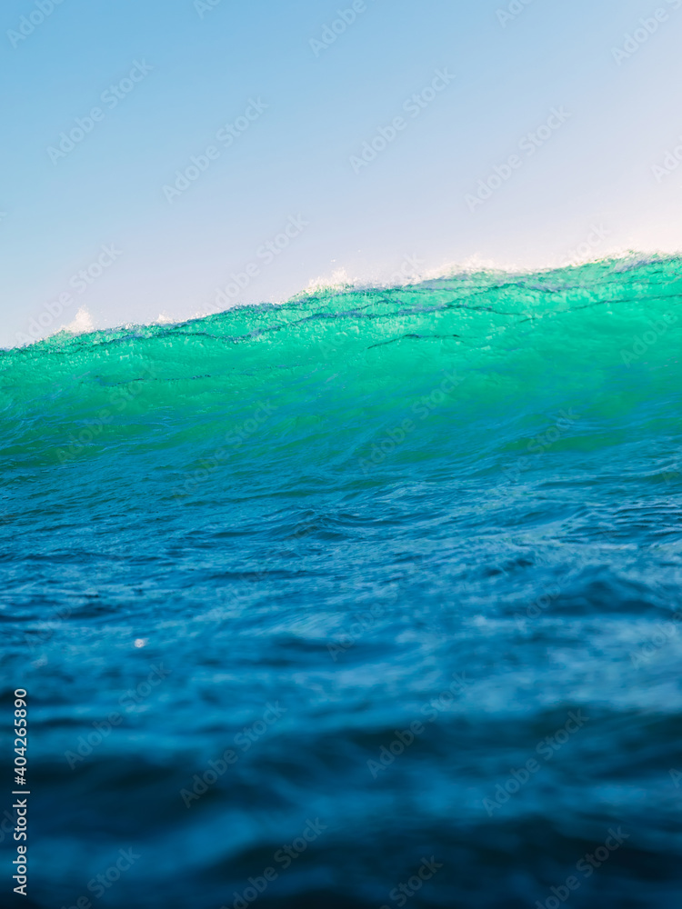 Perfect surfing wave in sea. Breaking turquoise wave with sun light Perfect surfing wave in sea. Breaking turquoise wave with sun light