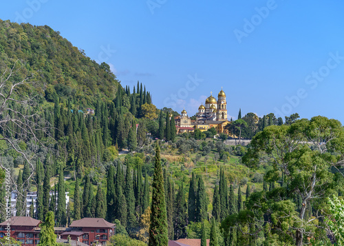 monastery in the mountains. panorama of the mountain valley, where the old famous Novo-Athos (Abkhazia) monastery with golden domes and gardens is located. many cypresses and fruit trees