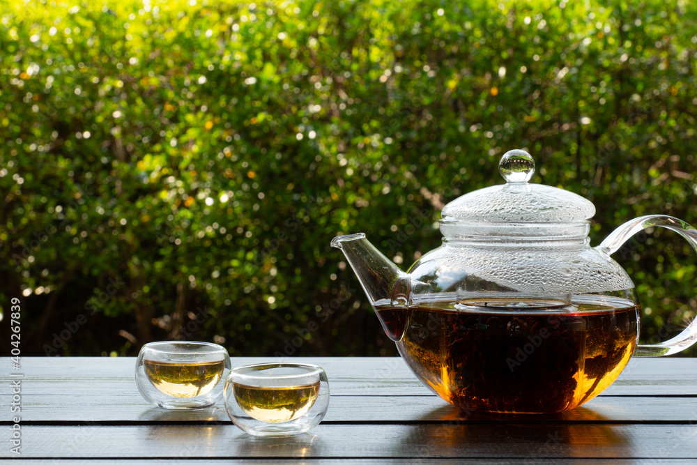 picture of people pouring hot water into clear glass kettle to make tea in afternoon in garden picture of people pouring hot water into clear glass kettle to make tea in afternoon in garden