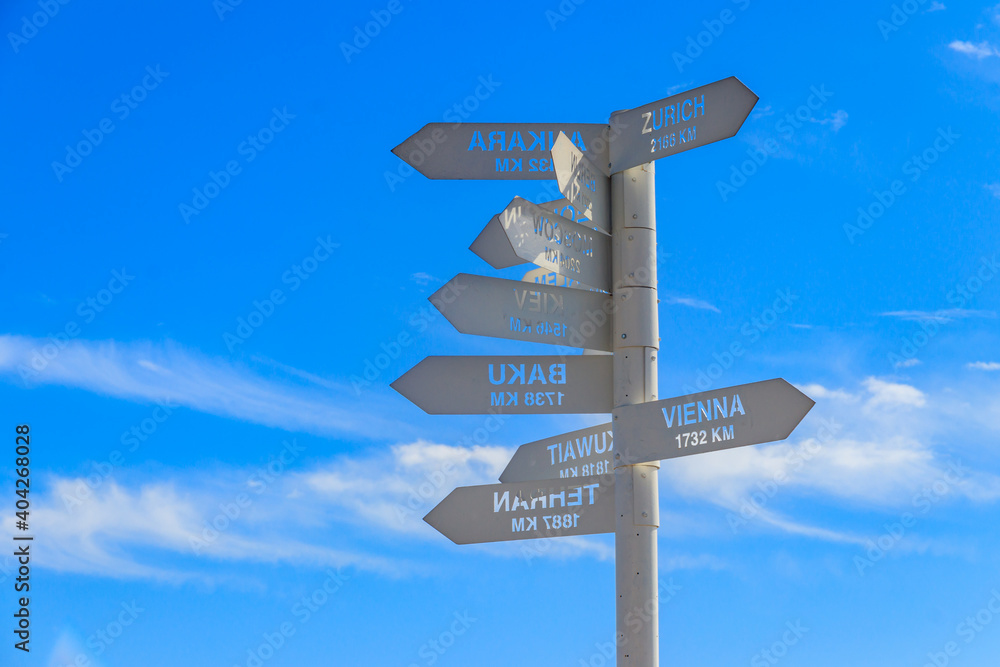 Sign indicating the directions and distances to major cities in the world on observation deck on a top of Tahtali mountain near Kemer, Antalya Province in Turkey Sign indicating the directions and distances to major cities in the world on observation deck on a top of Tahtali mountain near Kemer, Antalya Province in Turkey