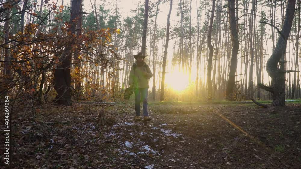 A backpacker with a guitar and a camera walks in the forest. Travel concept. 4K A backpacker with a guitar and a camera walks in the forest. Travel concept. 4K