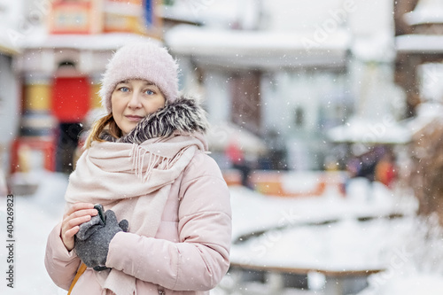 Portrait of a young woman in warm winter clothes outdoors while traveling. Winter time, snow © Светлана Густова