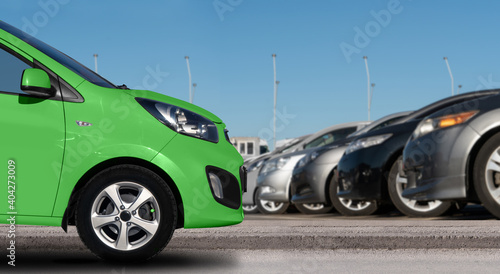 Green car on a background of cars in a rows. 
