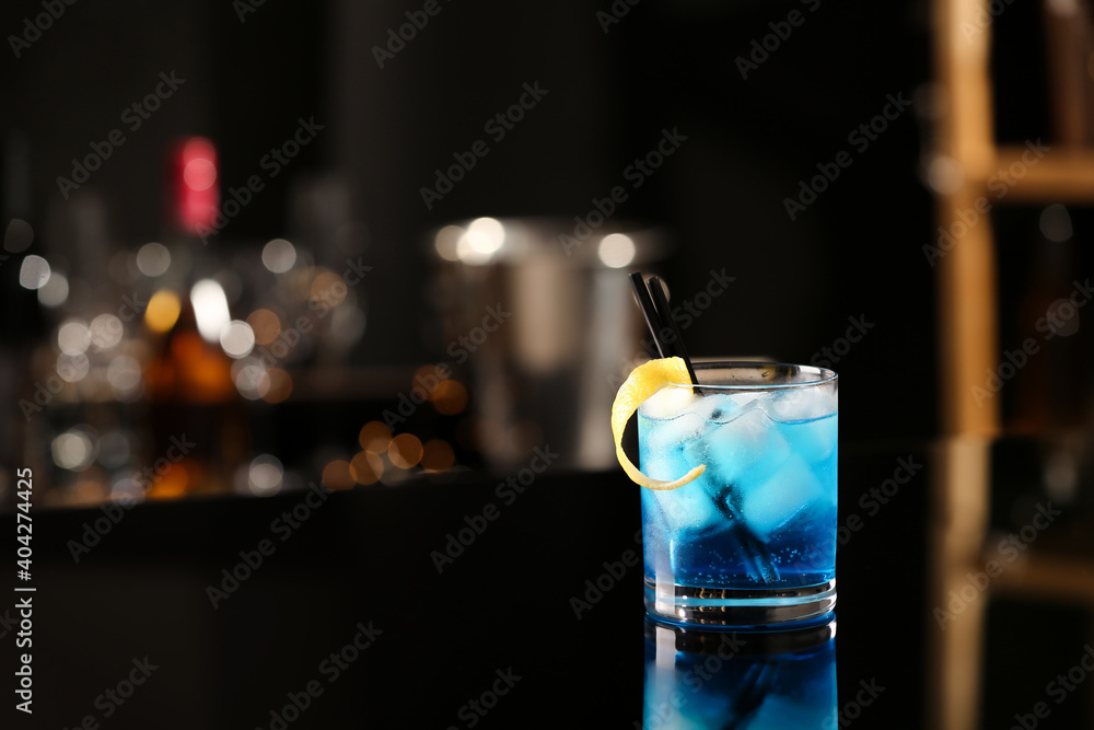 Glass of fresh alcoholic cocktail on bar counter, space for text