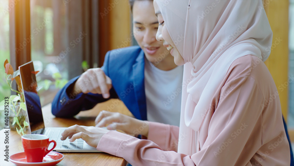 Obraz premium Upwardly mobile Asian Muslim business entrepreneur SME start up group of young man and women, discussing sale and marketing analysis, Asian Muslim SME teamwork e-commerce concept