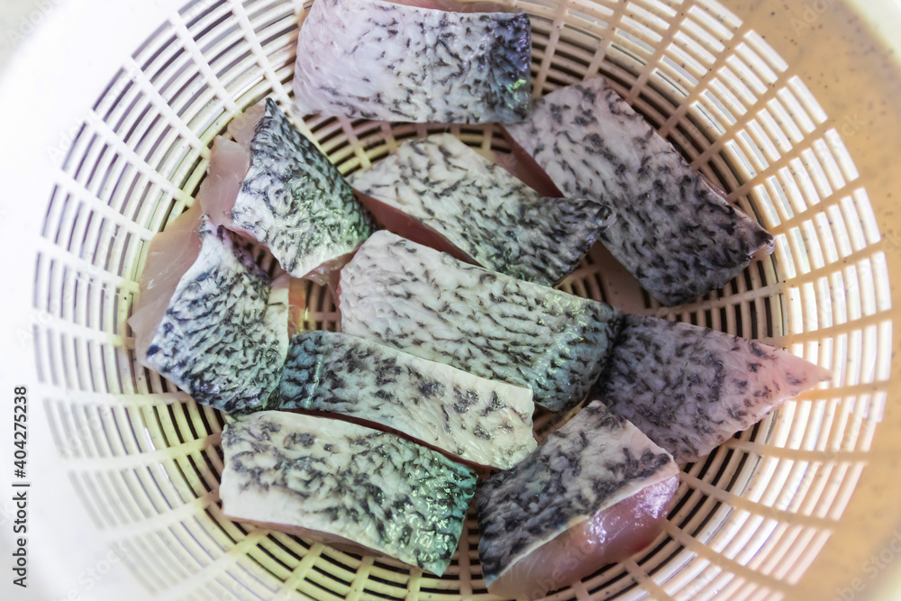 Fillet of fresh sea bass fish in strainer drain after washing. Fillet of fresh sea bass fish in strainer drain after washing.