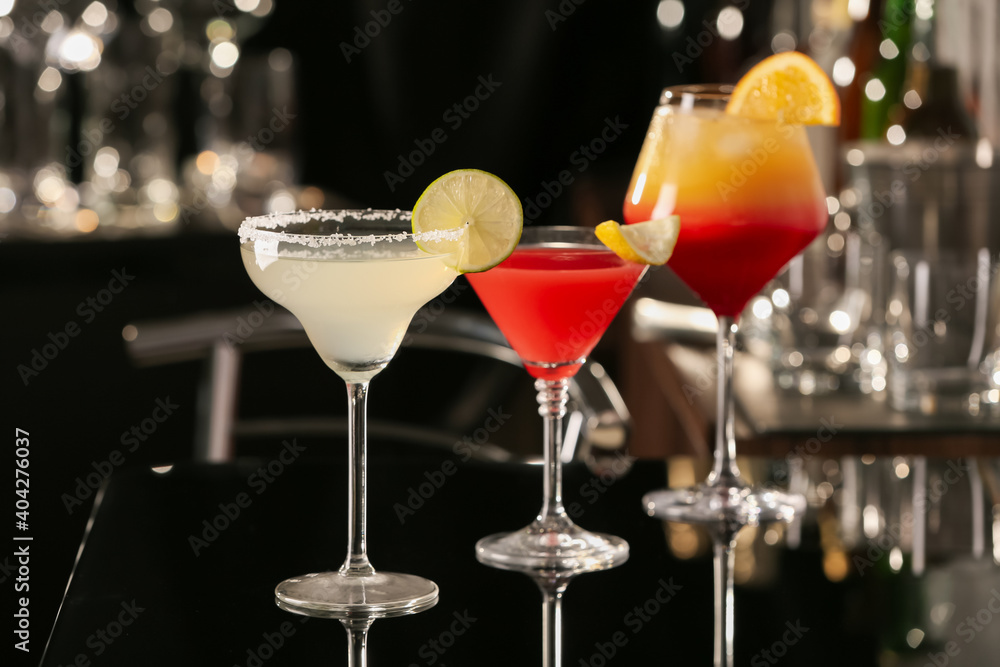 Different delicious cocktails on black table in bar Different delicious cocktails on black table in bar