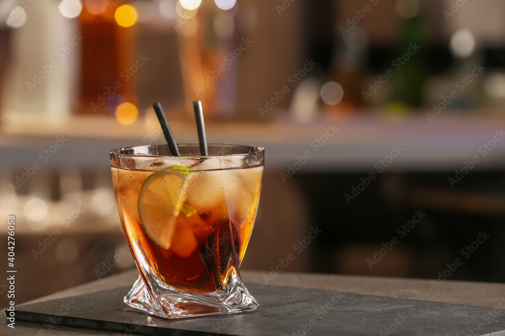 Cuba Libre cocktail on table in bar. Space for text Cuba Libre cocktail on table in bar. Space for text