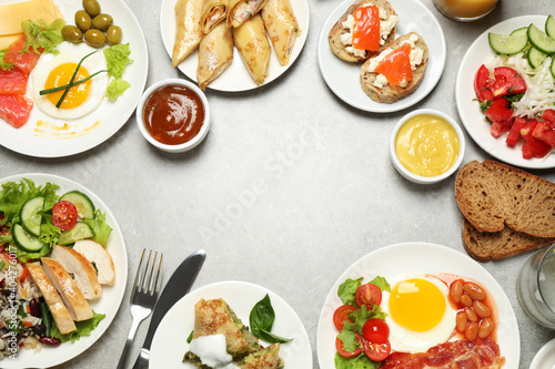 Buffet service. Frame of many different dishes on light grey table  space for text