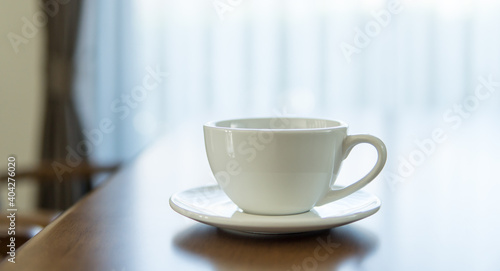 Close up of hot coffee cup on wooden table.