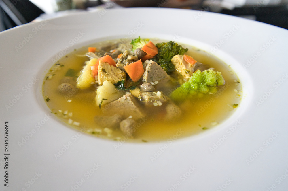 Ein weißer Teller Gemüsesuppe, Hühnersuppe mit Karotten, Leberknödel und Bio Gemüse, Produktbild Ein weißer Teller Gemüsesuppe, Hühnersuppe mit Karotten, Leberknödel und Bio Gemüse, Produktbild