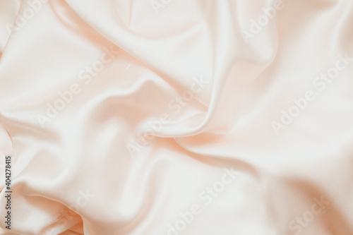 Powdery pink texture of silk, satin. Shiny fabric background.