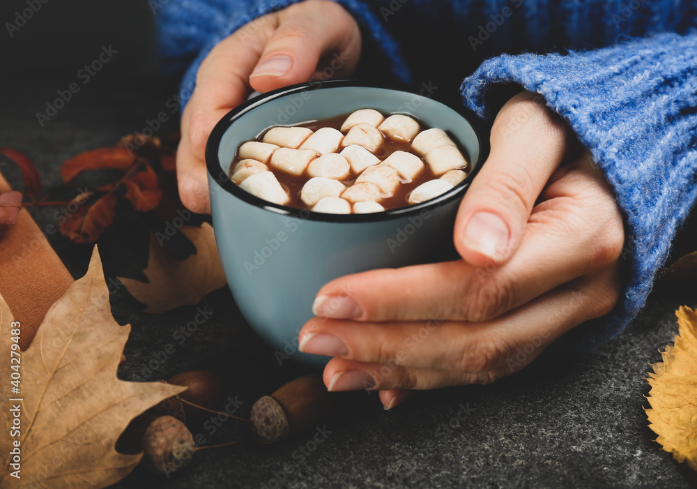Woman with cup of hot drink at grey table, closeup. Cozy autumn atmosphere Woman with cup of hot drink at grey table, closeup. Cozy autumn atmosphere