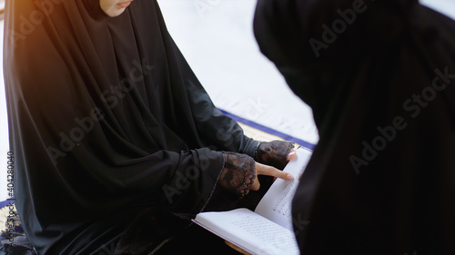 Portrait of an Asian muslim women in a daily prayer at home reciting Surah al-Fatiha passage of the Qur'an in a single act of Sujud called a Sajdah or prostration photo