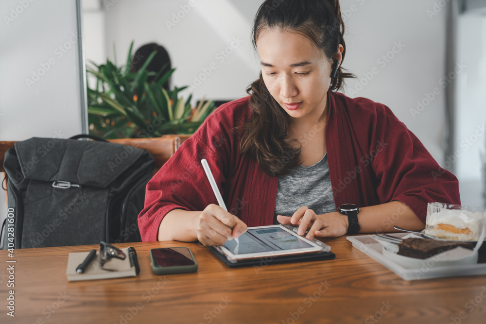 smart Asian woman copywriter working freelance project in modern cafe. Businesswoman using smartphone and tablet, searching information on website. Successful business. Online training courses concept smart Asian woman copywriter working freelance project in modern cafe. Businesswoman using smartphone and tablet, searching information on website. Successful business. Online training courses concept