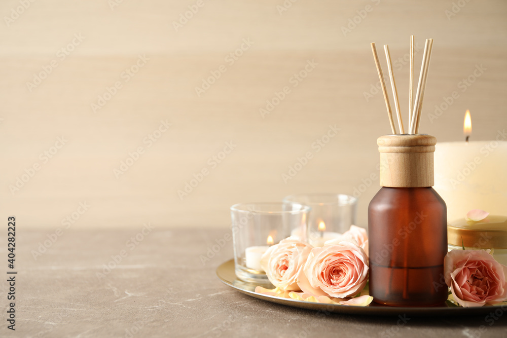 Spa composition with aroma oil and roses on grey table, space for text - obrazy, fototapety, plakaty 
