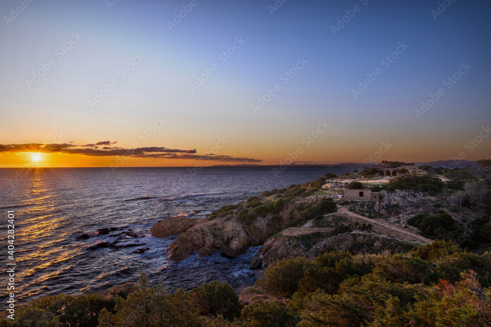 Sunset or sunrise with seaside villa, cliff, orange red and blue colors