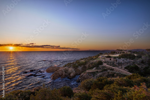 Sunset or sunrise with seaside villa, cliff, orange red and blue colors